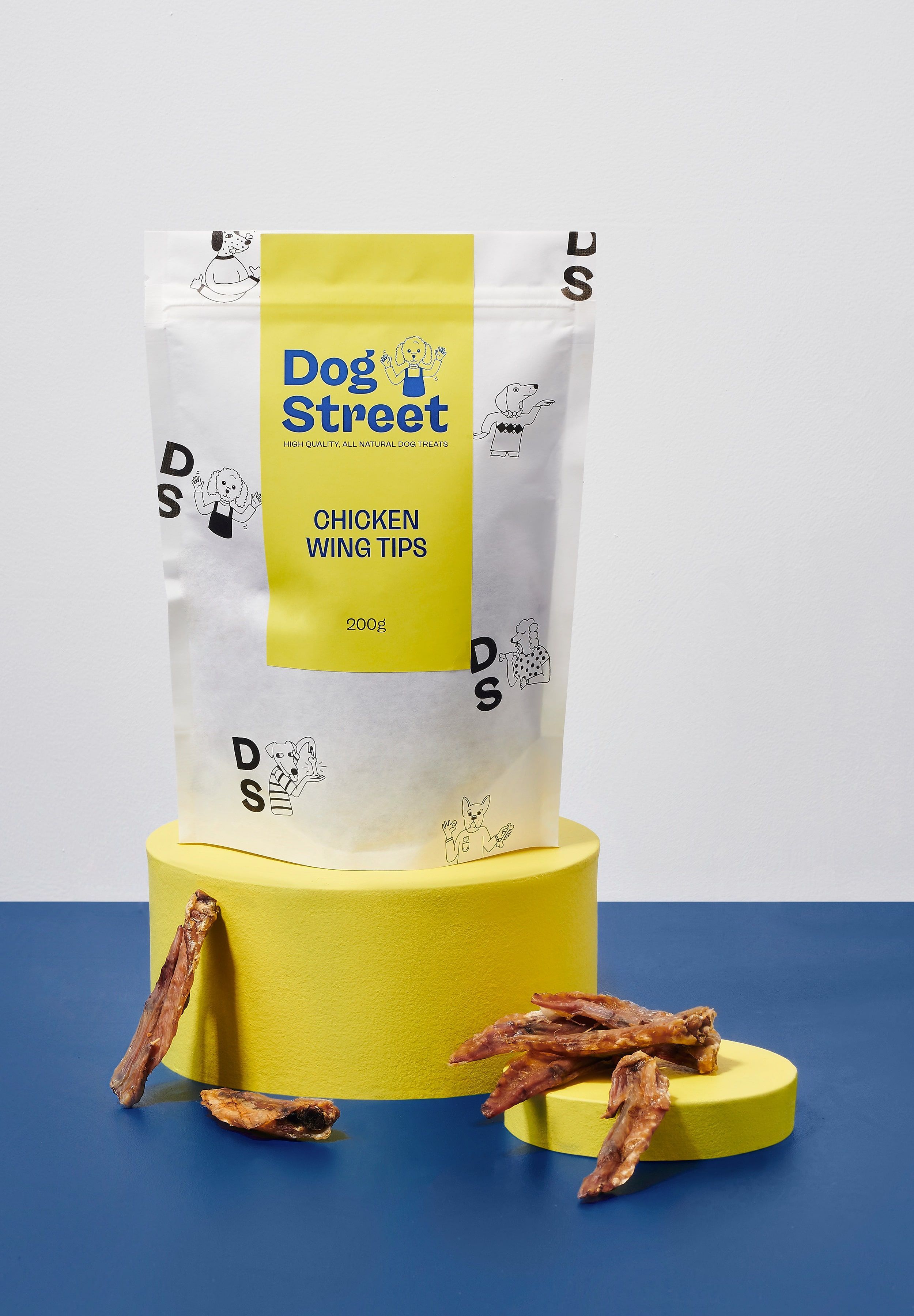 Styled shot of Dog Street Chicken Wing Tips pack and treats.