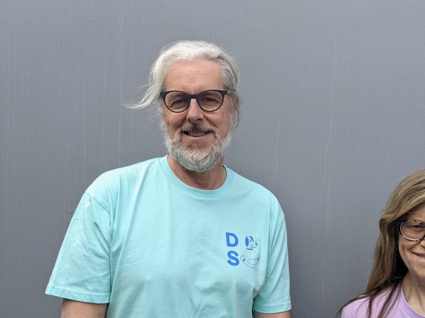 A man, Peter, in a blue Dog Street T-shirt. 