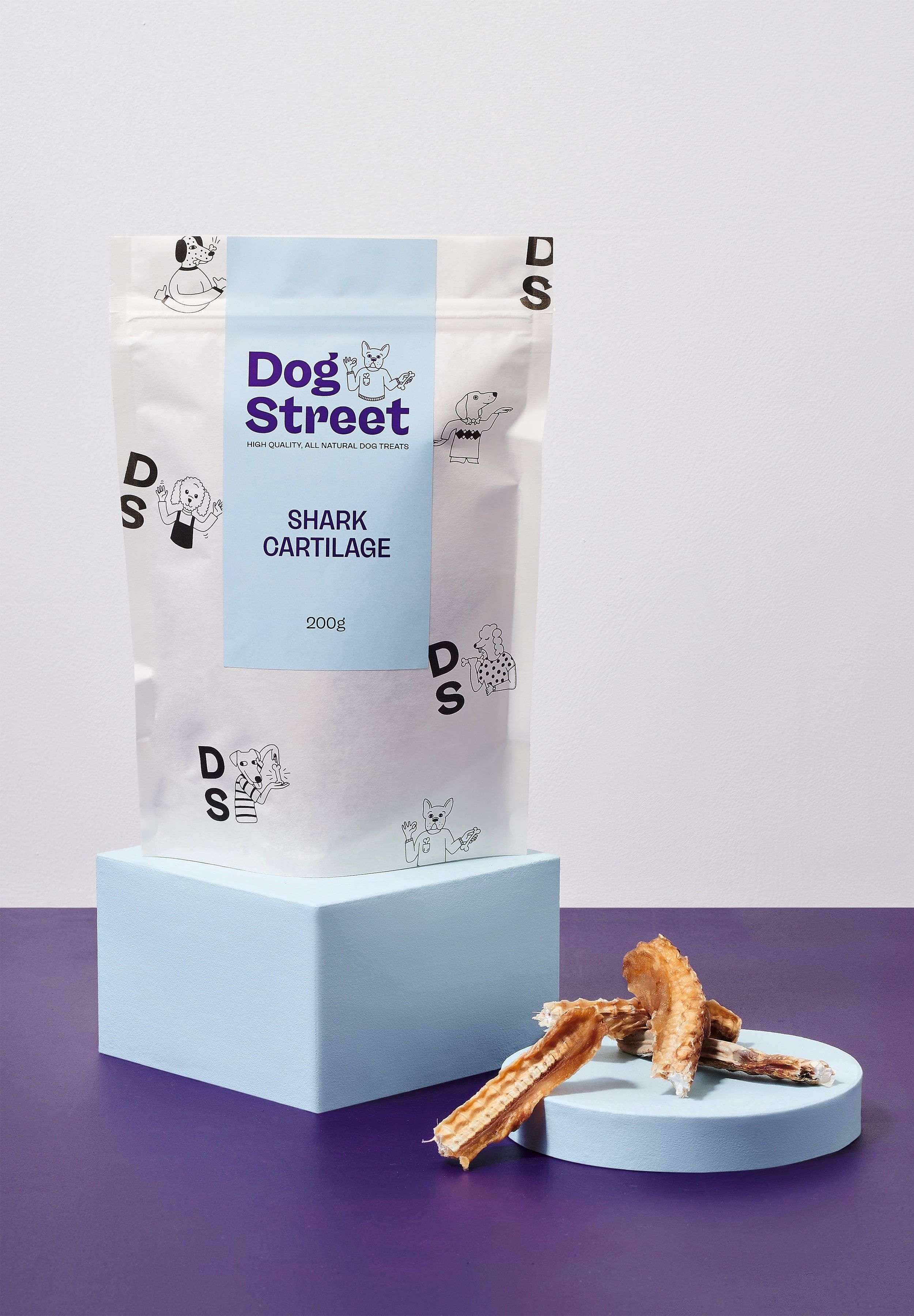 Styled shot of Dog Street Shark Cartilage pack and treats.